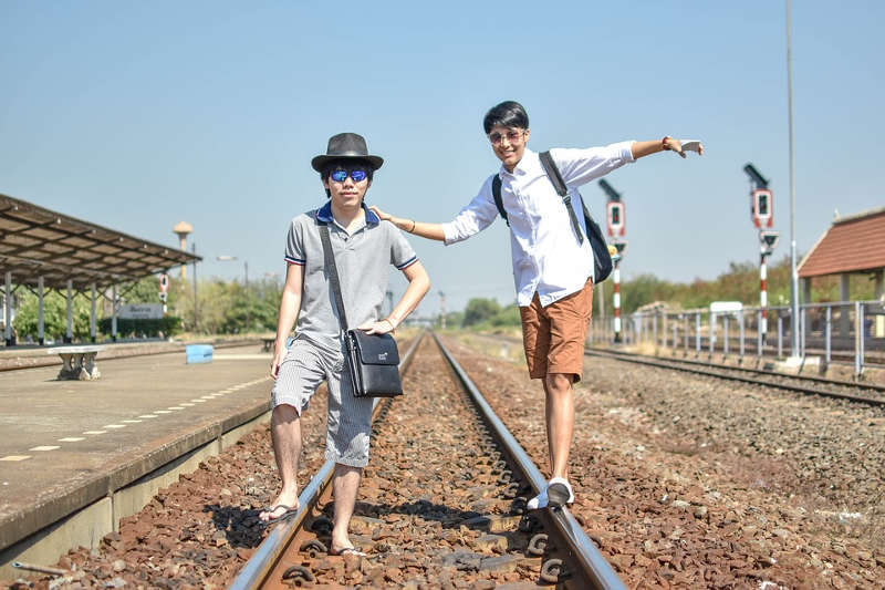 Twee toeristen op een spoorwegovergang in Thailand.