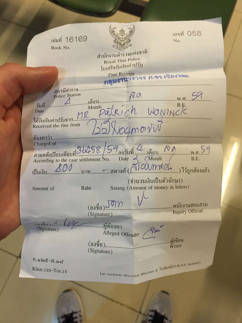 Een foto van een bekeuring voor het niet hebben van een rijbewijs in Thailand. Dit gecombineerd met het niet dragen van een helm.