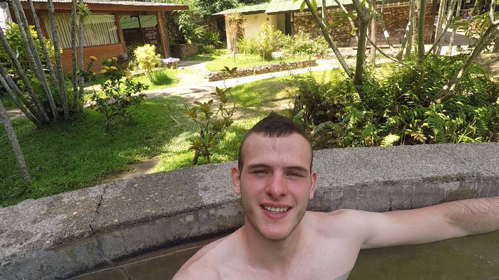 Afbeelding van een jonge reiziger die aan het ronddobberen is in een van de warm water baden van het Pai hotsprings resort.