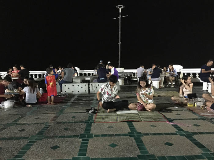 Afbeelding van zittende mensen die eten bij de Bangsaen night market.