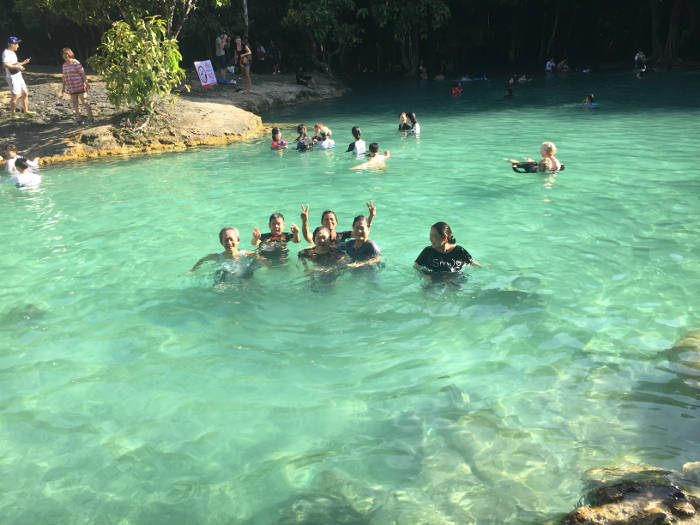 Afbeelding van een familie die de Emerald pool bezoeken.